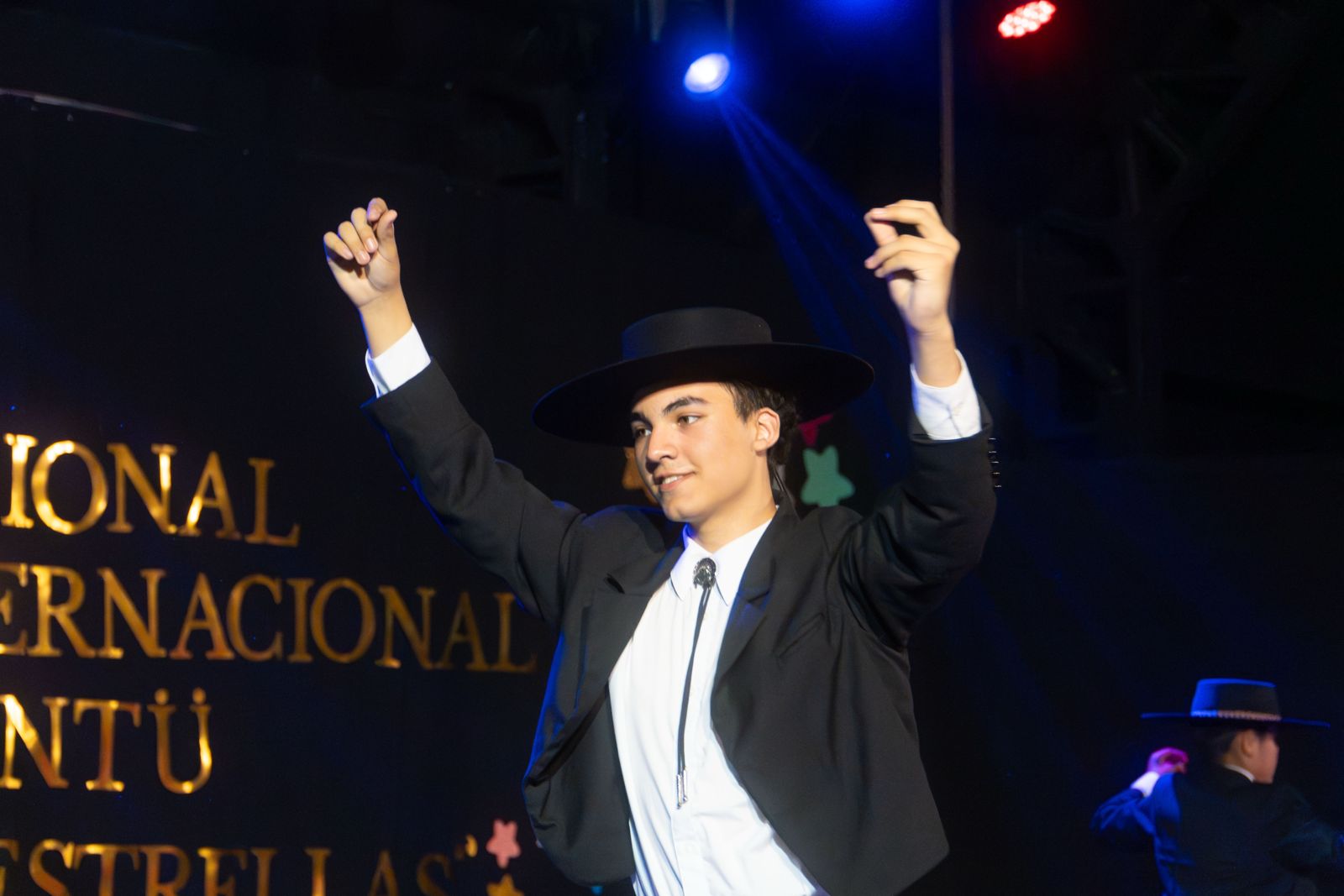 Bailarín de cueca con sombrero levantando los brazos
